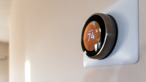 a circular smart thermostat installed on a white wall