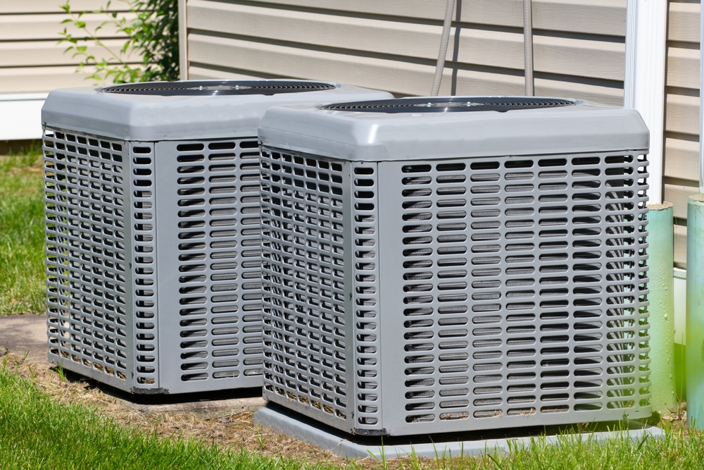 Two air conditioning units sitting in direct sunlight to warn against the dangers of sun exposure