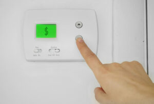 A thermostat with a dollar sign on the display screen to symbolize the cost of heating a home