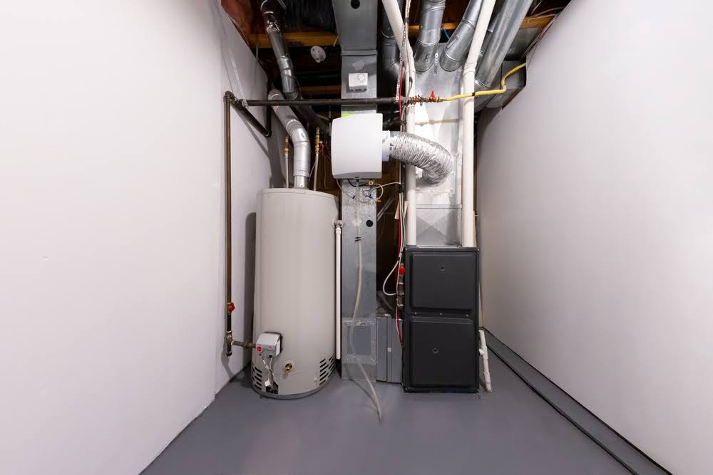 A furnace installed in a utility room next to a water heater