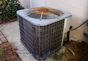 A rusty air conditioner outside of a home