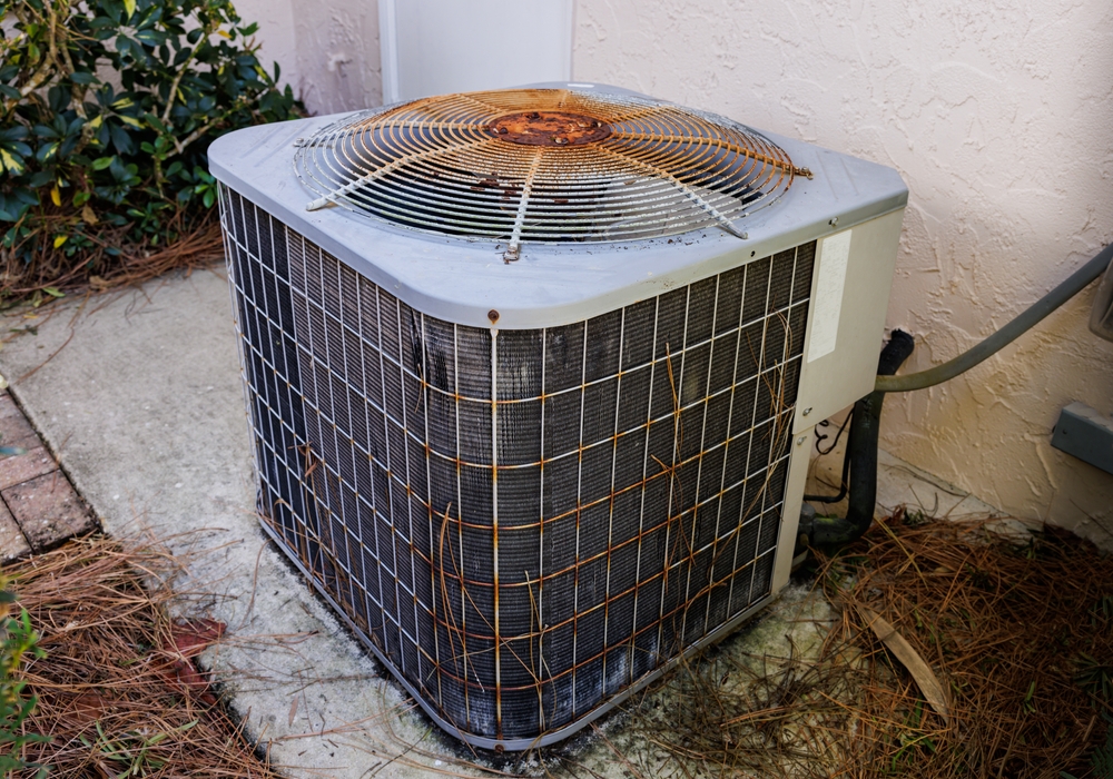 A rusty air conditioner outside of a home